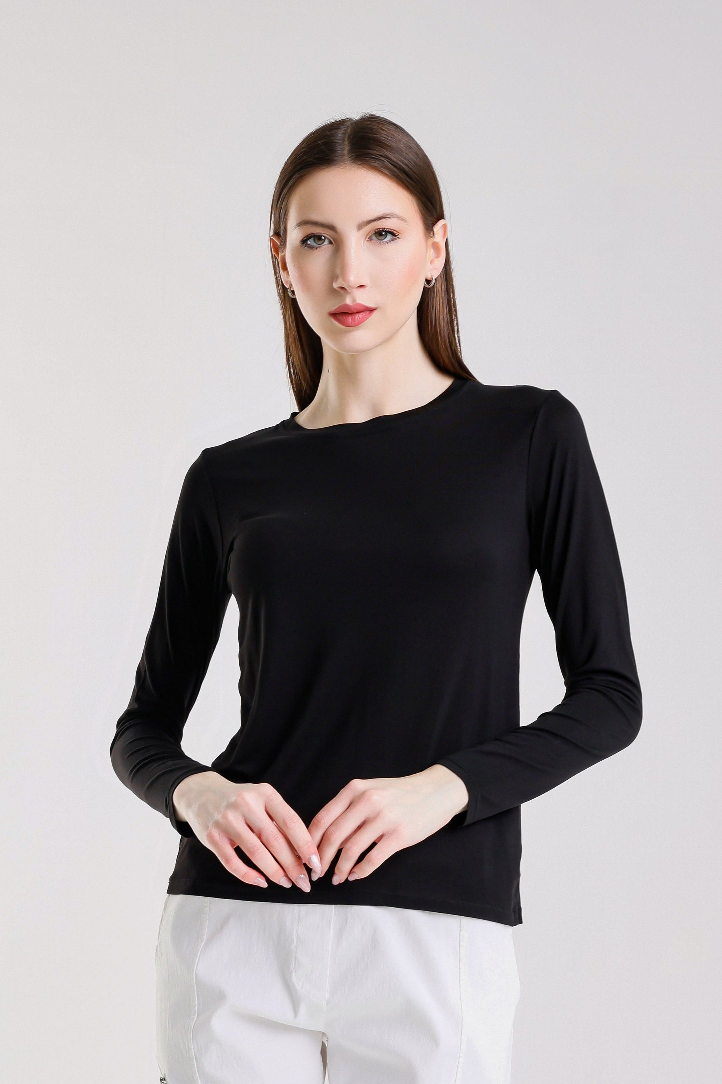 Woman wearing a black long-sleeve top against a white background